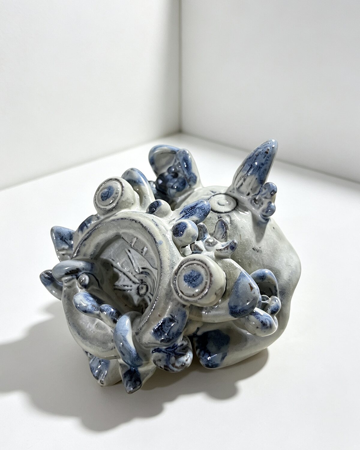 Hand-built blue-and-white Wama cat ornament