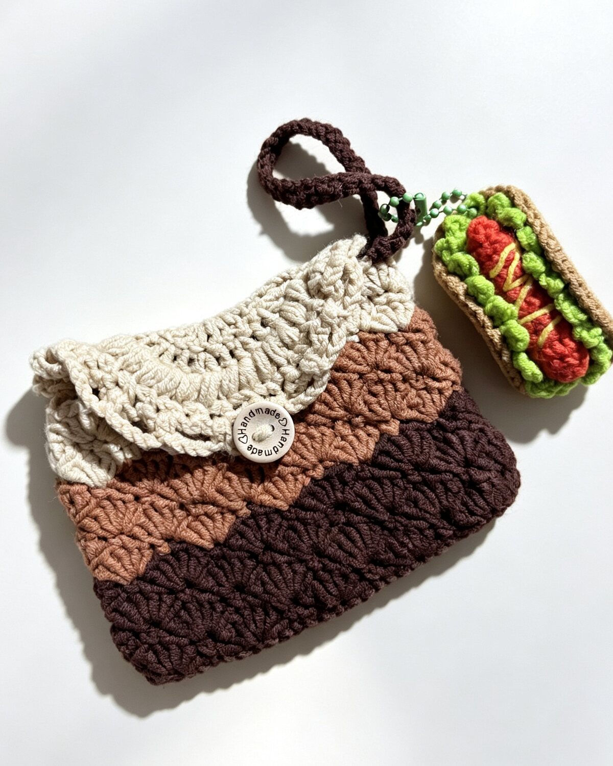Hand-crocheted brown and cream card holder with a hot-dog charm